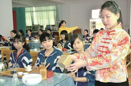 茶藝師正在給英德市職業(yè)技術(shù)學校茶藝興趣班學生演示茶藝的標準動作。