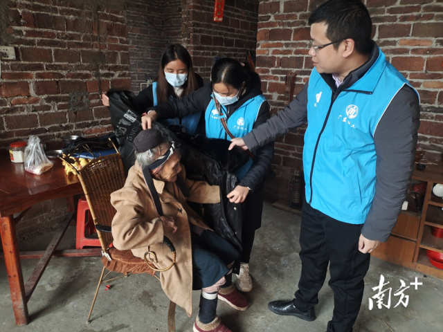 連南瑤族自治縣香坪鎮(zhèn)社工站為困難高齡老人送去御寒棉衣，并幫老人穿上棉衣。